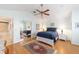 Bedroom with light blue walls, hardwood floors, ceiling fan, and ensuite bathroom at 589 Society Hill Cir, The Villages, FL 32162