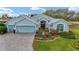 Charming single-story home with a well-manicured lawn, red door, and three-car garage, creating inviting curb appeal at 589 Society Hill Cir, The Villages, FL 32162