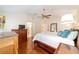 Another angle of the bright main bedroom featuring hardwood floors and a ceiling fan at 589 Society Hill Cir, The Villages, FL 32162