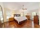 Bright main bedroom featuring hardwood floors, a ceiling fan, and windows providing ample natural light at 589 Society Hill Cir, The Villages, FL 32162