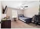 Cozy bedroom with a ceiling fan, window with shutters, and dark furniture at 5890 Sw 167Th Pl, Ocala, FL 34473