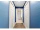 Hallway with brown carpet, light blue walls, and white doors leading to other rooms at 5890 Sw 167Th Pl, Ocala, FL 34473