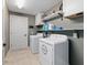 Bright laundry room with tile flooring, utility sink, and modern washer and dryer at 5890 Sw 167Th Pl, Ocala, FL 34473