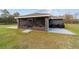 View of the home's backyard with a screened porch, patio area, and outdoor cooking equipment at 5890 Sw 167Th Pl, Ocala, FL 34473