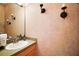 Classic half bathroom featuring a vanity, mirror, and sconces with decorative wallpaper at 6035 Falconbridge Pl, Mount Dora, FL 32757