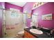 Bright bathroom with a glass-enclosed shower, modern fixtures, and vibrant purple walls at 6035 Falconbridge Pl, Mount Dora, FL 32757