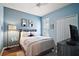 Cozy bedroom with blue walls, a comfortable bed, and tasteful decor creating a relaxing retreat at 6035 Falconbridge Pl, Mount Dora, FL 32757