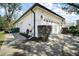 Side view of a two-car garage with a well-maintained yard at 6035 Falconbridge Pl, Mount Dora, FL 32757
