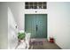 Close-up of the double front doors, showcasing the textured white walls, plants, and decorative door mat at 6035 Falconbridge Pl, Mount Dora, FL 32757