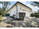 Exterior view of the two-car garage with an adjacent manicured landscaping at 6035 Falconbridge Pl, Mount Dora, FL 32757