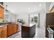 Eat-in kitchen featuring modern appliances, wood cabinets and central island with granite countertop at 6035 Falconbridge Pl, Mount Dora, FL 32757