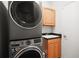 Efficient laundry room with a stacked washer and dryer unit and storage cabinetry at 6035 Falconbridge Pl, Mount Dora, FL 32757