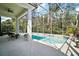 Screened-in pool area with a seating area surrounded by lush greenery at 6035 Falconbridge Pl, Mount Dora, FL 32757