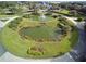 Aerial view of a community entrance featuring two ponds and lush landscaping around the edges at 6342 Sailboat Ave, Tavares, FL 32778