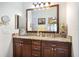 Bathroom featuring a double vanity with stone countertop, wooden cabinets and modern fixtures at 6342 Sailboat Ave, Tavares, FL 32778