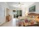 A serene bedroom with a colorful quilt, view to the outdoor space and a ceiling fan at 6342 Sailboat Ave, Tavares, FL 32778