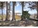 Lake view through mature trees from shore with a covered dock, and dock side platform at 6342 Sailboat Ave, Tavares, FL 32778