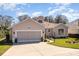 Inviting single-Gathering home showcases a spacious driveway, manicured lawn, and a well-maintained exterior at 6342 Sailboat Ave, Tavares, FL 32778