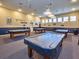 Game room with multiple pool tables under soft lighting for leisure and recreation at 6342 Sailboat Ave, Tavares, FL 32778