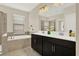 Bright bathroom featuring a double vanity, soaking tub, and tiled floor at 9040 Azalea Sands Ln, Davenport, FL 33896