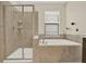 Bathroom with tiled tub, shower combo, and small corner shelves at 9040 Azalea Sands Ln, Davenport, FL 33896