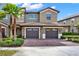 Charming townhome featuring a well-kept brick driveway, two-car garage, and lush landscaping at 9040 Azalea Sands Ln, Davenport, FL 33896