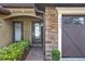 Inviting front entrance with stone accents, brick walkway, and dark-stained door, offering great curb appeal at 9040 Azalea Sands Ln, Davenport, FL 33896