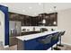 Modern kitchen featuring a breakfast bar, stainless steel appliances, and sleek dark cabinetry at 9040 Azalea Sands Ln, Davenport, FL 33896