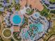 Overhead shot of a complex pool with slides, lounge chairs, umbrellas and palm trees at 9040 Azalea Sands Ln, Davenport, FL 33896