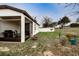 Exterior view of the backyard featuring a screened in porch with grill, outdoor seating and a small fire pit at 9188 Chandler Dr, Groveland, FL 34736