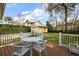 Outdoor deck with table and chairs overlooking well-maintained backyard and detached garage at 932 N Mcdonald St, Mount Dora, FL 32757