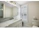 Bathroom with a marble countertop vanity, white cabinetry and plantation shutters at 932 N Mcdonald St, Mount Dora, FL 32757