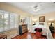 Bright bedroom with hardwood floors, ceiling fan, and plenty of natural light from two large windows at 932 N Mcdonald St, Mount Dora, FL 32757