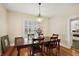 Dining room featuring a chandelier, hardwood floors, and natural light from the window at 932 N Mcdonald St, Mount Dora, FL 32757