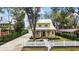 Aerial view of a charming yellow two-story home with a well-manicured lawn and white picket fence at 932 N Mcdonald St, Mount Dora, FL 32757