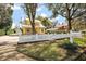 Exterior view of a yellow two story home with a white picket fence, and a detached garage at 932 N Mcdonald St, Mount Dora, FL 32757