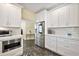 Bright kitchen featuring white cabinets, stainless steel appliances, and stylish tile flooring at 932 N Mcdonald St, Mount Dora, FL 32757