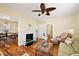 Cozy living room featuring hardwood floors, a brick fireplace, and comfortable seating at 932 N Mcdonald St, Mount Dora, FL 32757