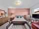 Traditional bedroom with a pink accent wall, wooden furniture, and plenty of natural light at 9829 Wedgewood Ln, Leesburg, FL 34788