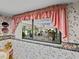 Dining room window with pink floral wallpaper, offering a view of the outdoors at 9829 Wedgewood Ln, Leesburg, FL 34788