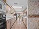 Functional kitchen with light wood cabinets, white countertops, and a bright, skylit ceiling at 9829 Wedgewood Ln, Leesburg, FL 34788