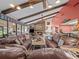 Spacious living room with stone fireplace, wood beam ceiling, and sliding glass doors at 9829 Wedgewood Ln, Leesburg, FL 34788