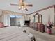 Bright main bedroom with large dresser, ceiling fan, and sliding glass door to patio at 9829 Wedgewood Ln, Leesburg, FL 34788