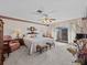 Main bedroom with ceiling fan, upholstered seating, and sliding glass doors to patio at 9829 Wedgewood Ln, Leesburg, FL 34788