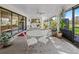 Bright sunroom with glass table set, lots of plants, and sliding doors to the interior, perfect for entertaining at 9829 Wedgewood Ln, Leesburg, FL 34788