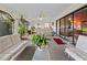 Relaxing sunroom with lots of plants, comfortable seating, ceiling fan, and sliding glass doors to the home's interior at 9829 Wedgewood Ln, Leesburg, FL 34788