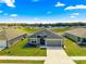 Aerial view of a single-Gathering home with a well-manicured lawn, trees, and neighborhood at 10420 E 161St St, Summerfield, FL 34491