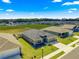 Aerial view of a gray home with a manicured lawn in a residential neighborhood at 10420 E 161St St, Summerfield, FL 34491