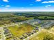 Wide aerial view of single Gathering homes nestled in a sprawling neighborhood community and wooded area at 10420 E 161St St, Summerfield, FL 34491