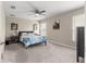 Spacious bedroom with ceiling fan, plush carpeting, and bright natural light from large windows at 10420 E 161St St, Summerfield, FL 34491